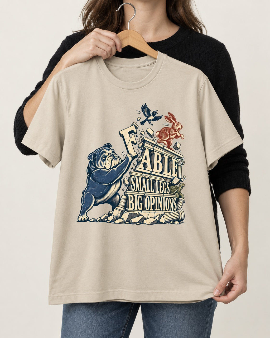 Small Legs Big Opinions English Bulldog T-Shirt in Sand, held up on a hanger