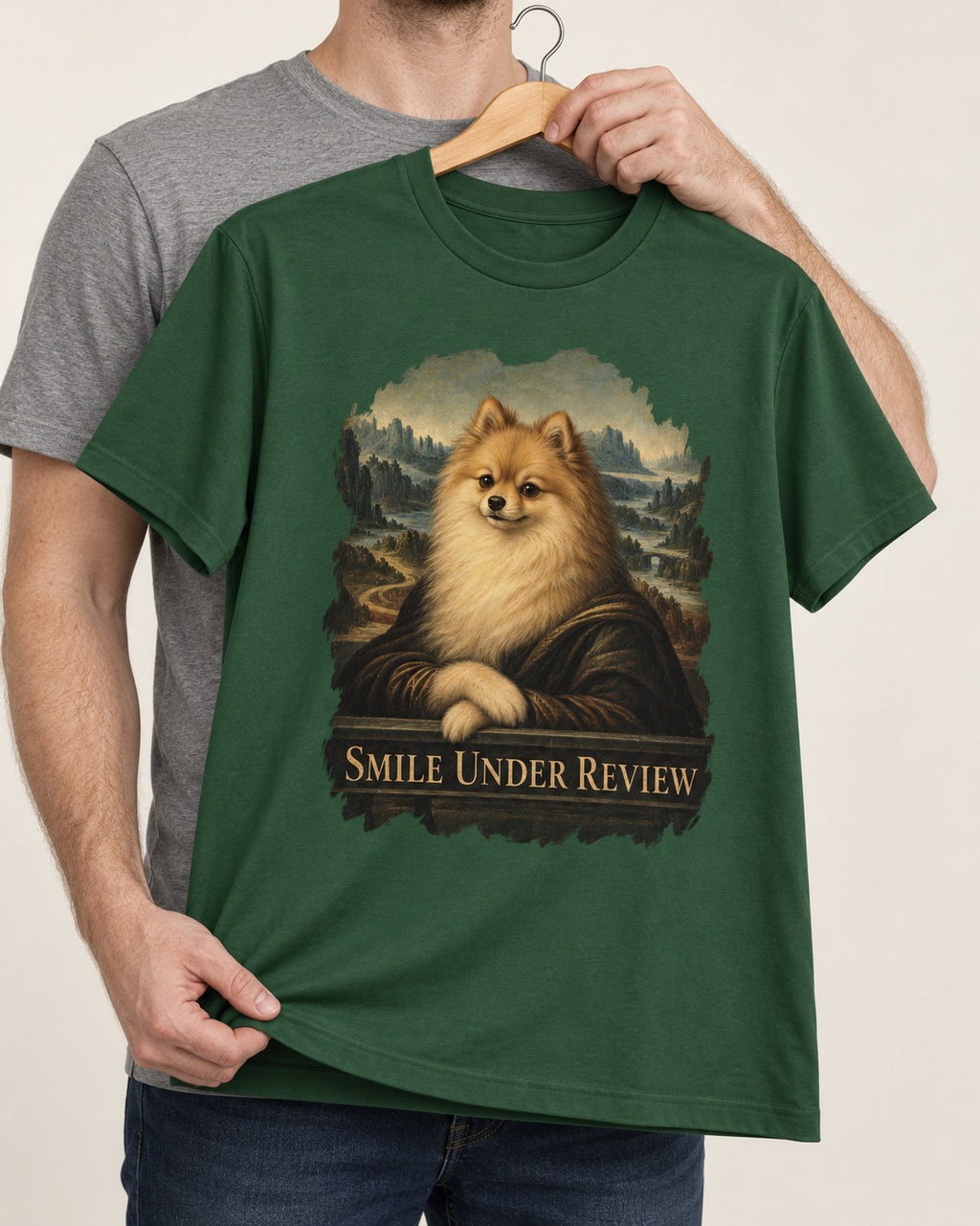 Pomeranian Smile Under Review Renaissance Portrait Graphic T-Shirt in Forest Green, held up on a hanger