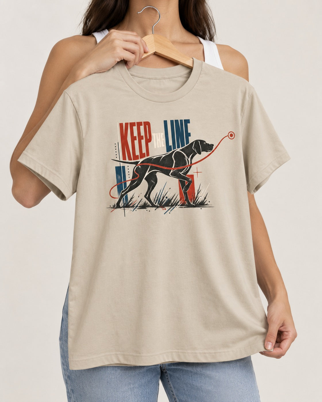 Keep the Line German Shorthaired Pointer T-Shirt in Sand, held up on a hanger