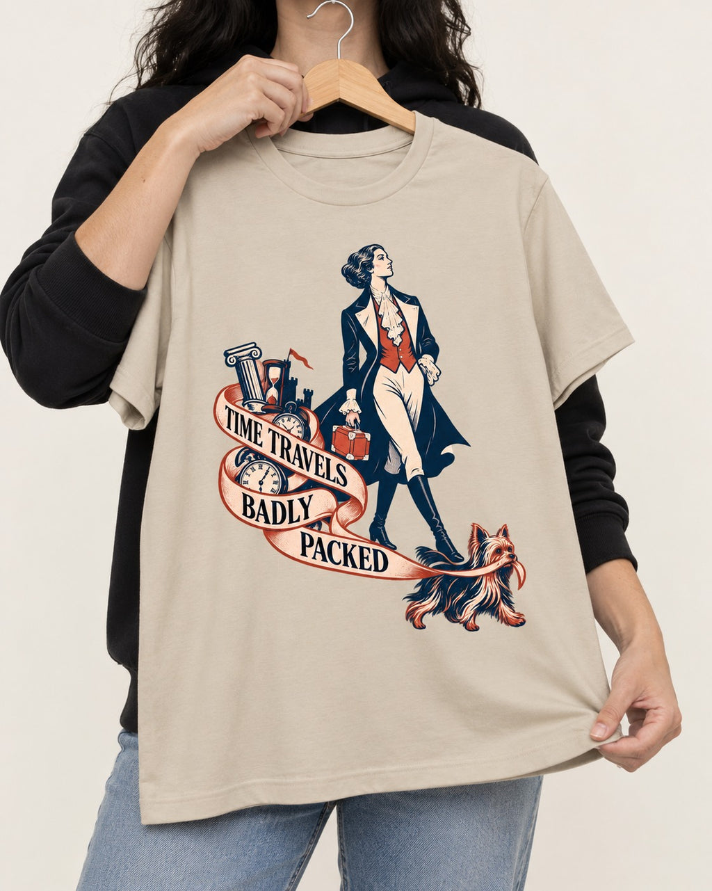 Time Travels Badly Packed Yorkshire Terrier T-Shirt in Sand, held up on a hanger