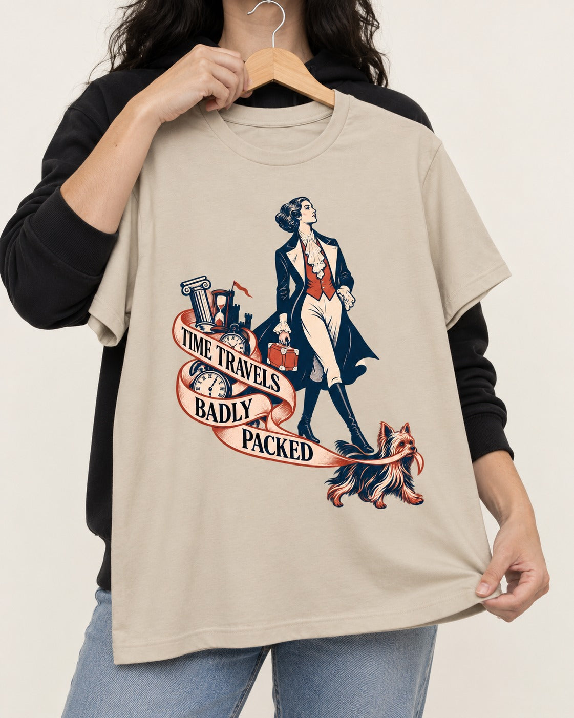 Time Travels Badly Packed Yorkshire Terrier T-Shirt in Sand, held up on a hanger