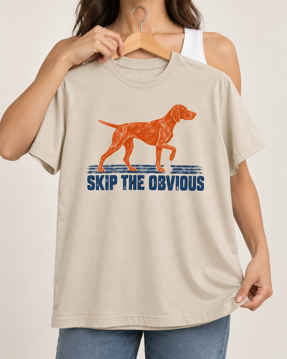 Skip the Obvious German Shorthaired Pointer T-Shirt in Sand, held up on a hanger