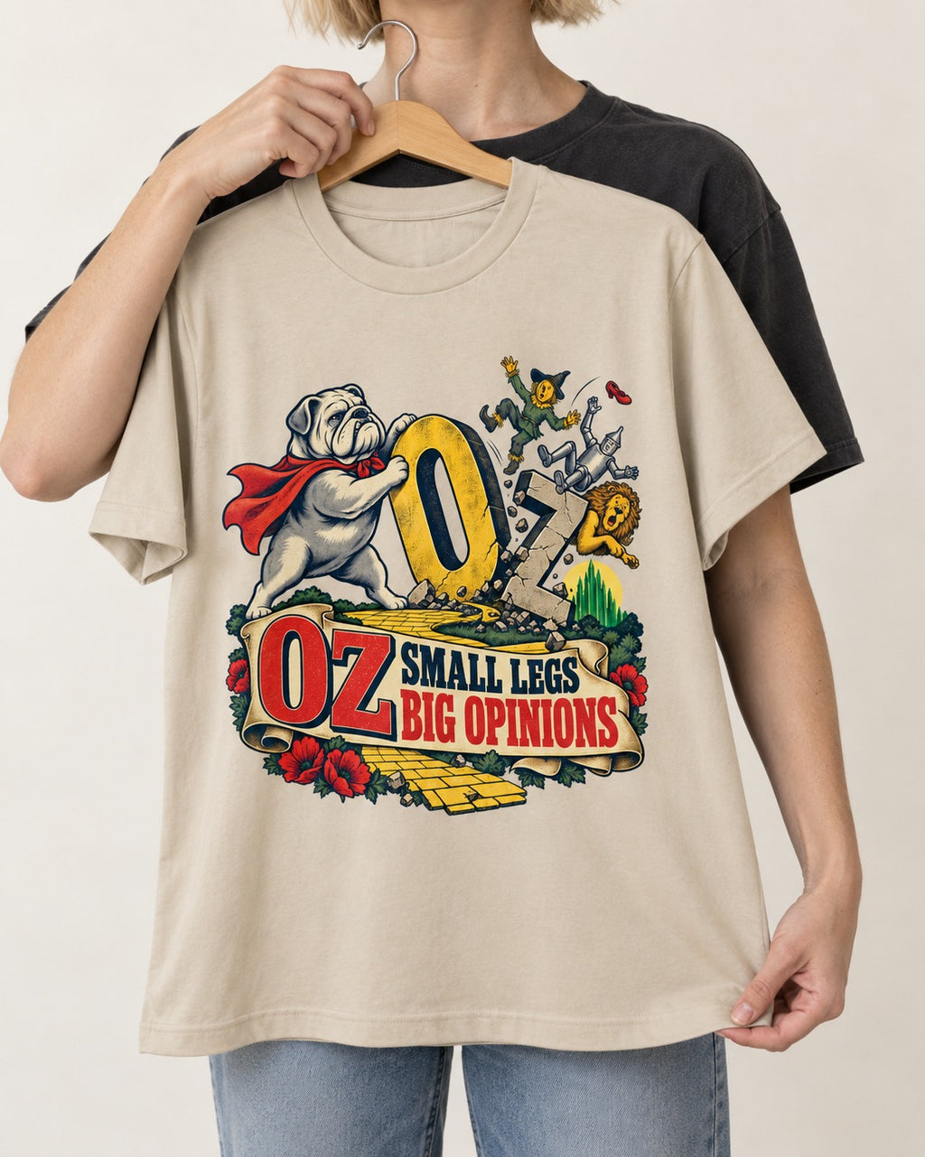 English Bulldog Small Legs Big Opinions T-Shirt in Sand, held up on a hanger