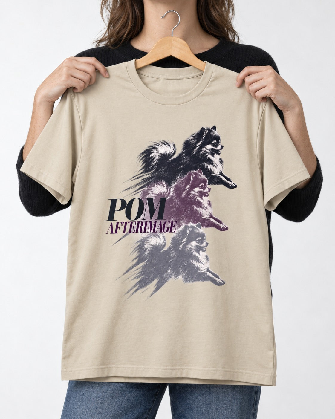 Pomeranian Afterimage T-Shirt in Sand, held up on a hanger