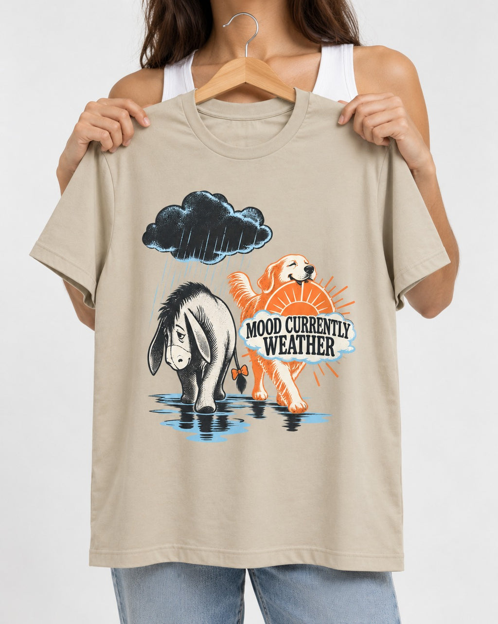 Mood Currently Golden Retriever Weather T-Shirt in Sand, held up on a hanger