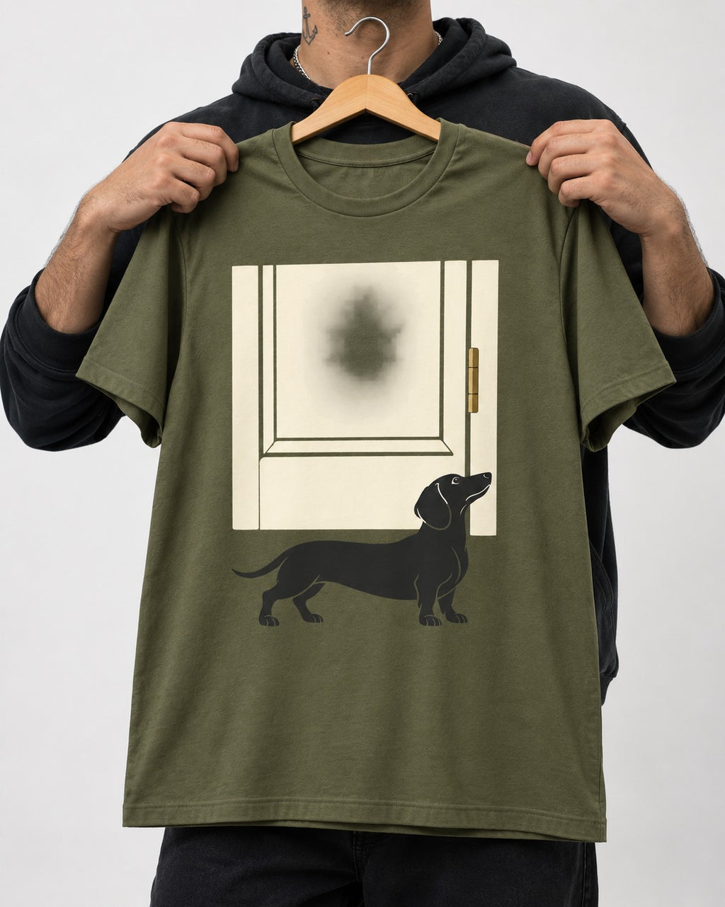 Dachshund Frosted Door Sentinel Graphic T-Shirt in Heather Military Green, held up on a hanger