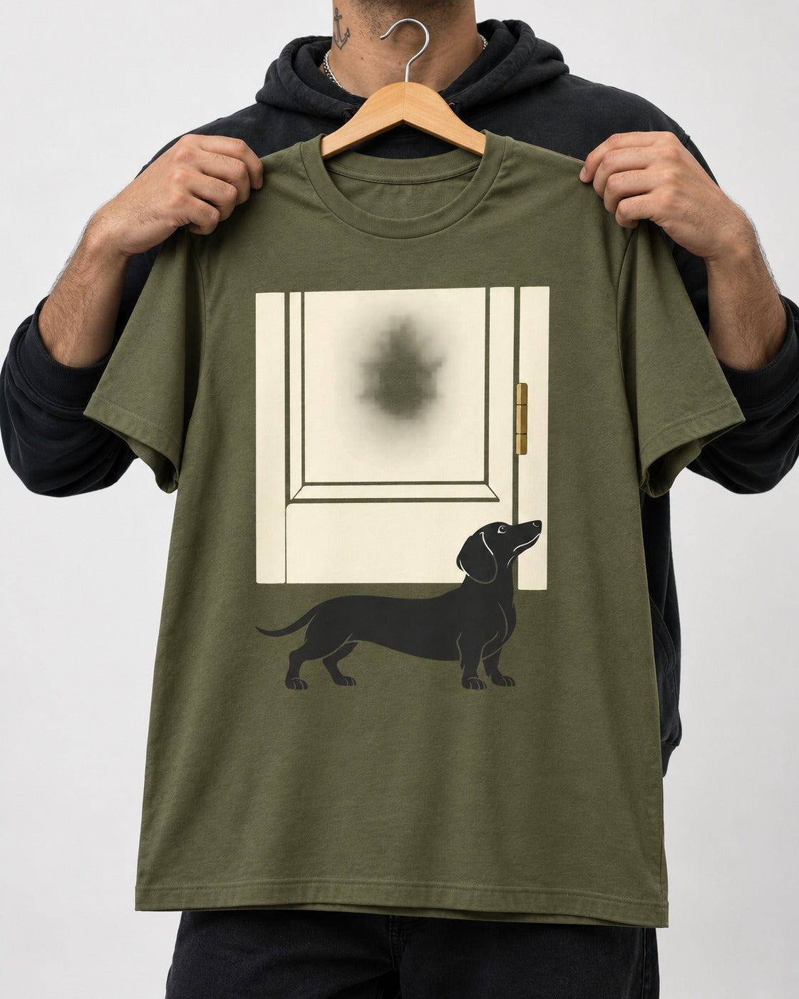 Dachshund Frosted Door Sentinel Graphic T-Shirt in Heather Military Green, held up on a hanger