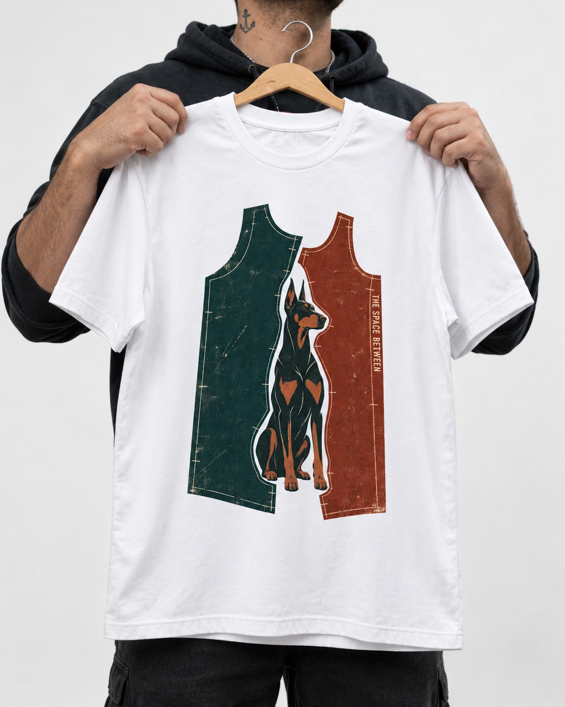 Doberman The Space Between Pattern Pieces Graphic T-Shirt in White, held up on a hanger