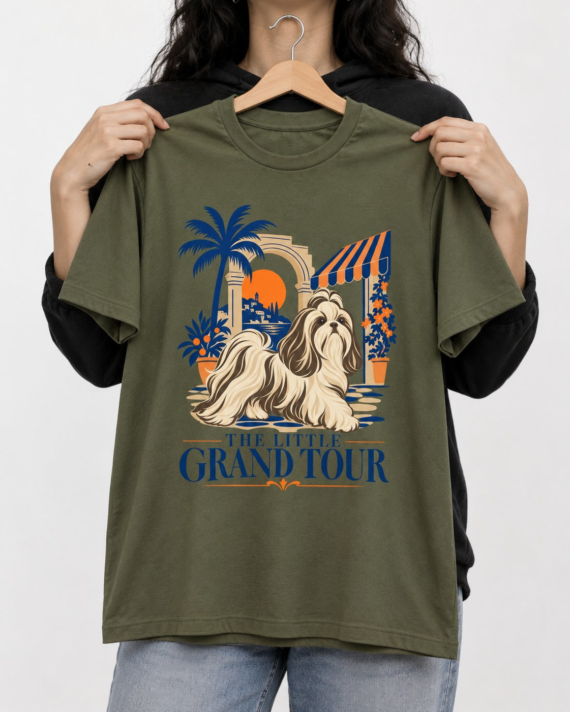 Shih Tzu The Little Grand Tour Mediterranean Courtyard Graphic T-Shirt in Heather Military Green, held up on a hanger