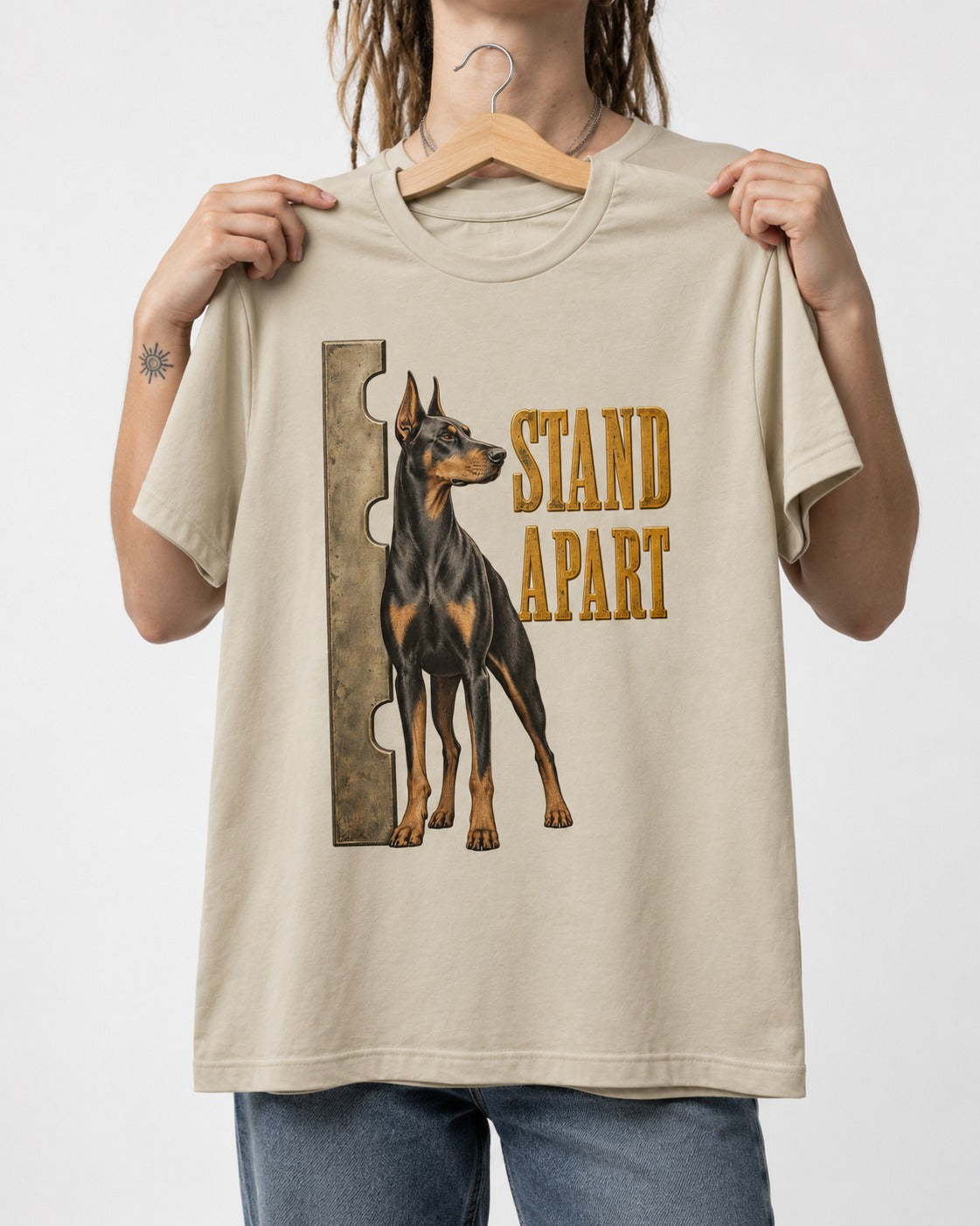 Doberman Stand Apart T-Shirt in Sand, held up on a hanger