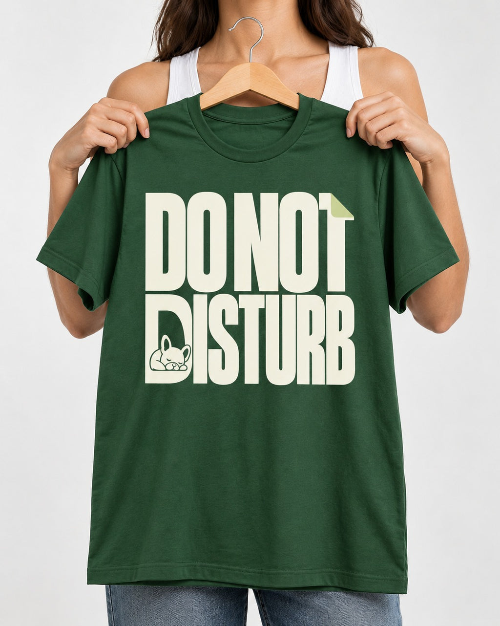 Frenchie Do Not Disturb Hidden Sleeping Graphic T-Shirt in Forest Green, held up on a hanger