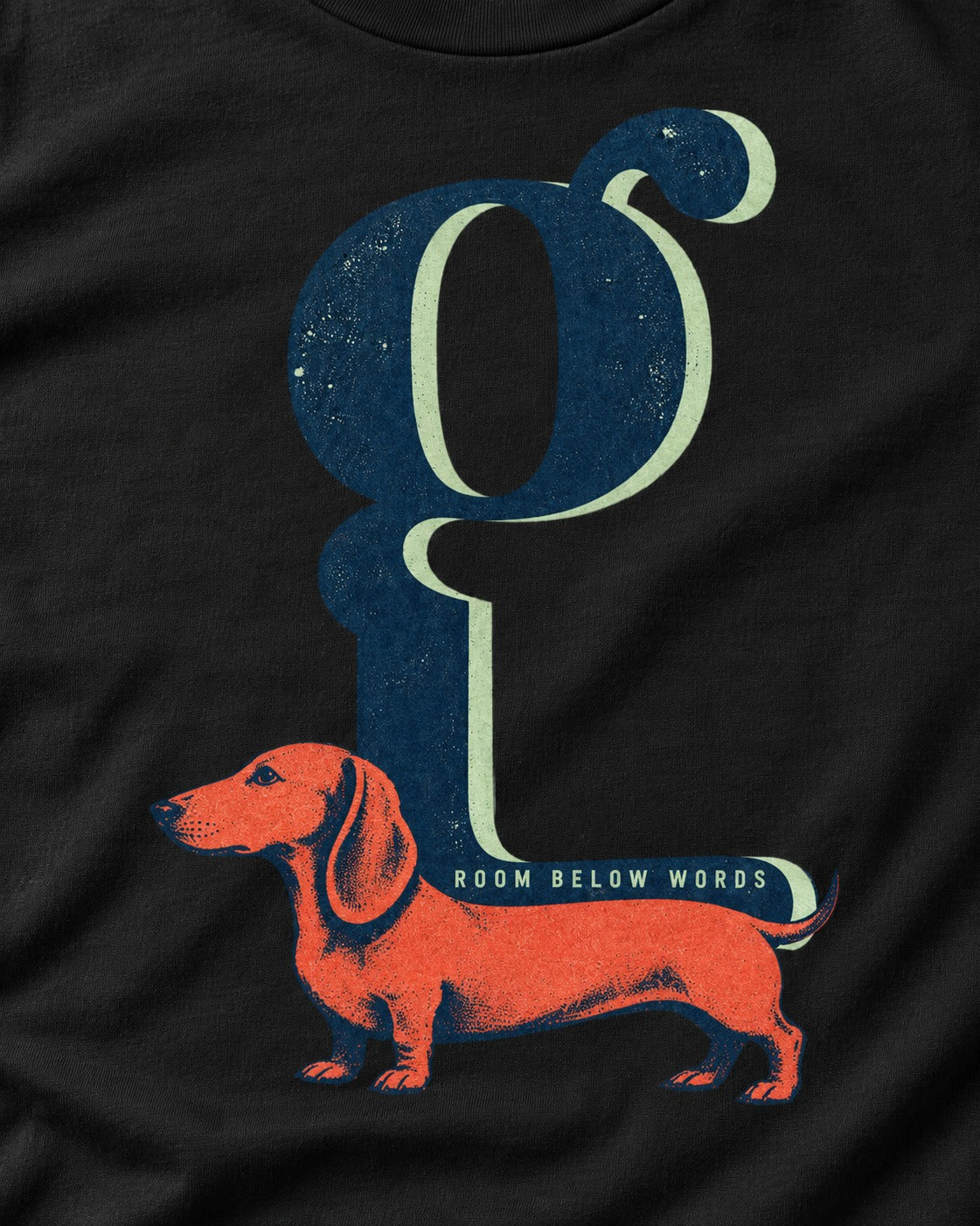 Dachshund Room Below Words Lowercase G Graphic T-Shirt in Black, close-up of the graphic