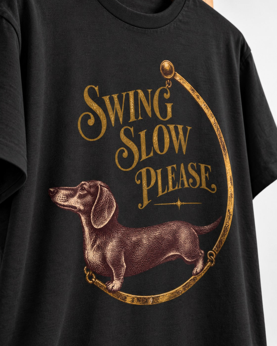 Dachshund Swing Slow Please Necklace Frame Graphic T-Shirt in Black, close-up of the graphic