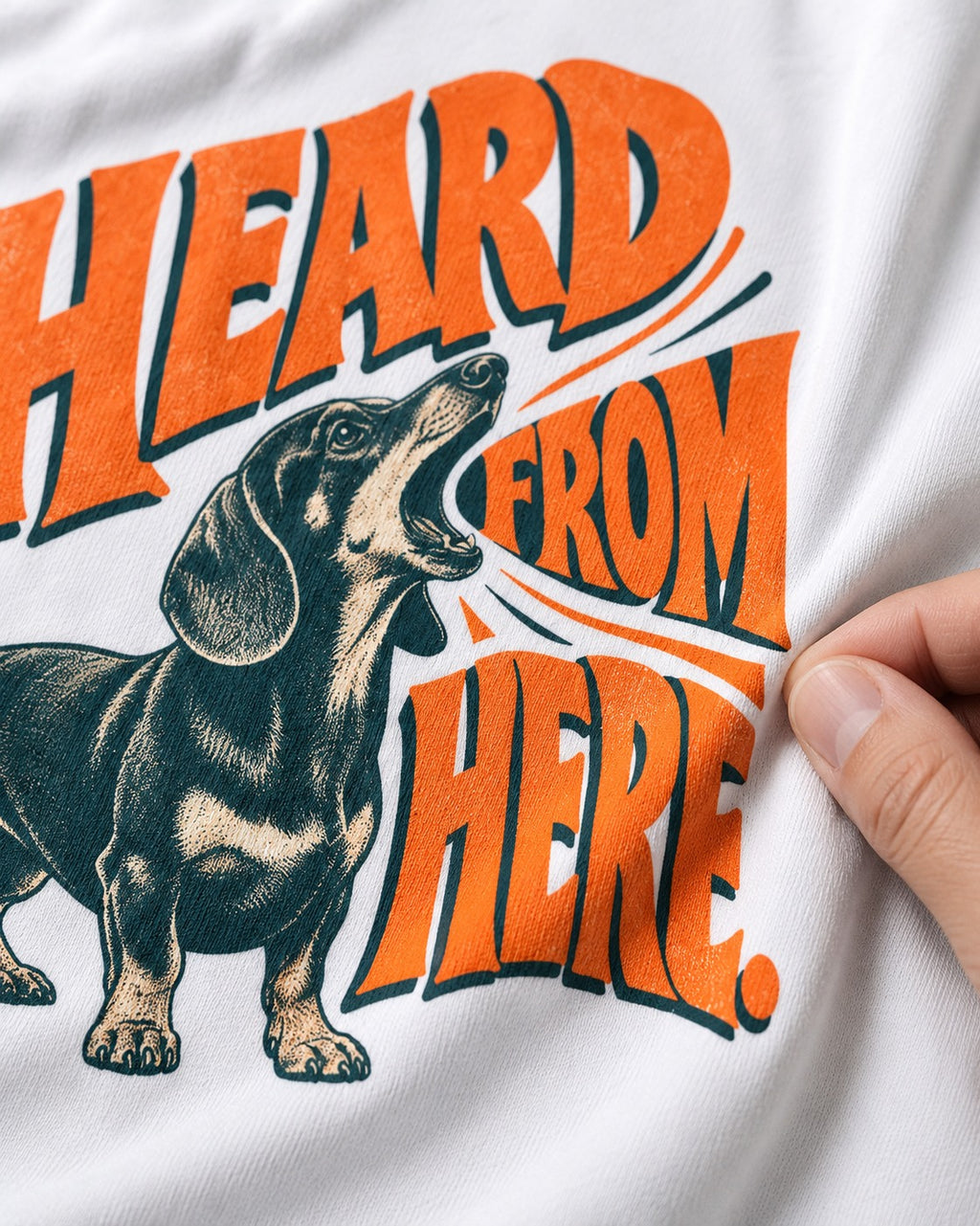 Dachshund Heard From Here T-Shirt in White, close-up of the graphic