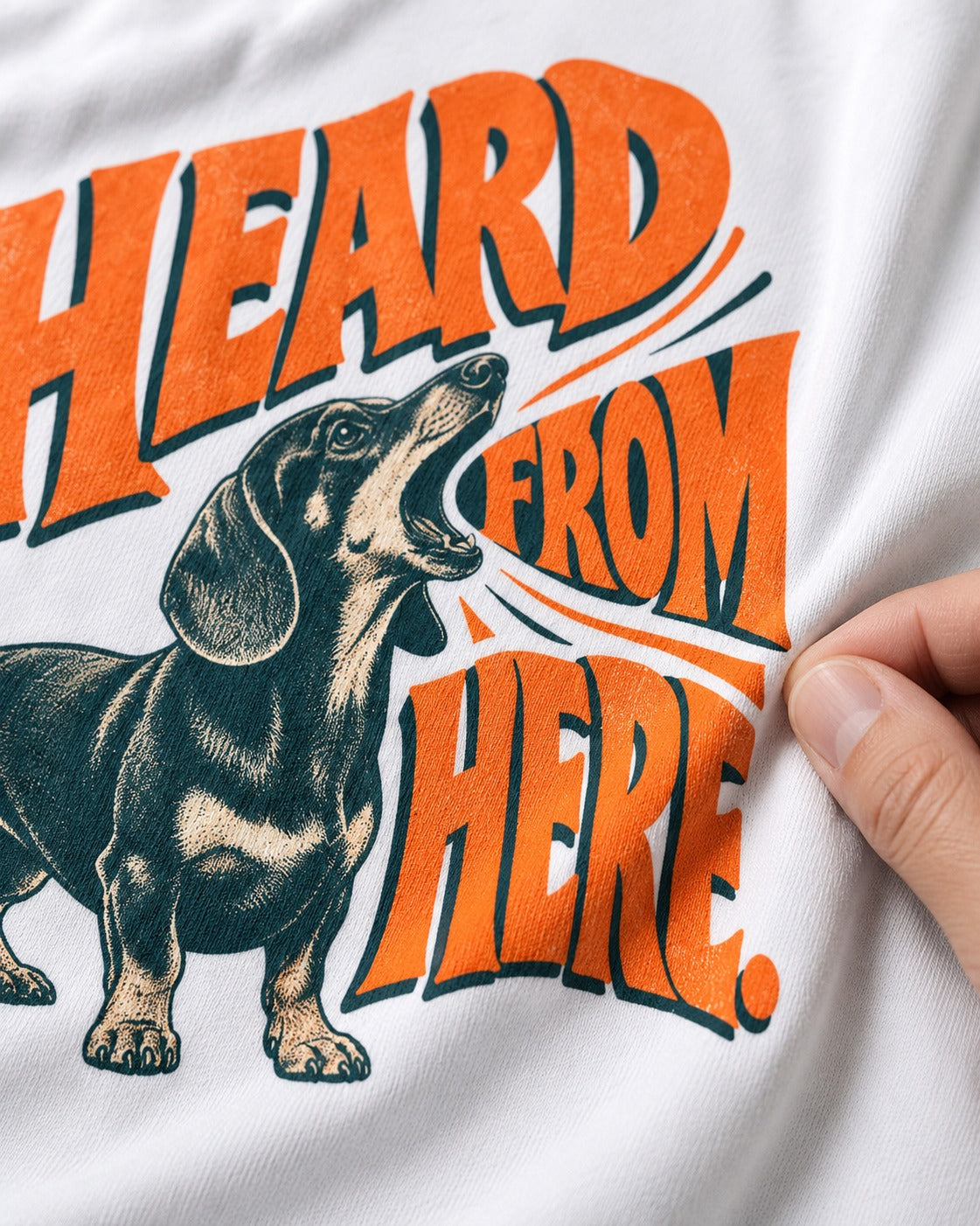 Dachshund Heard From Here T-Shirt in White, close-up of the graphic