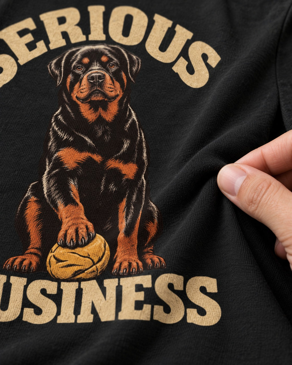 Rottweiler Serious Business Ball Under Paw Graphic T-Shirt in Black, close-up of the graphic