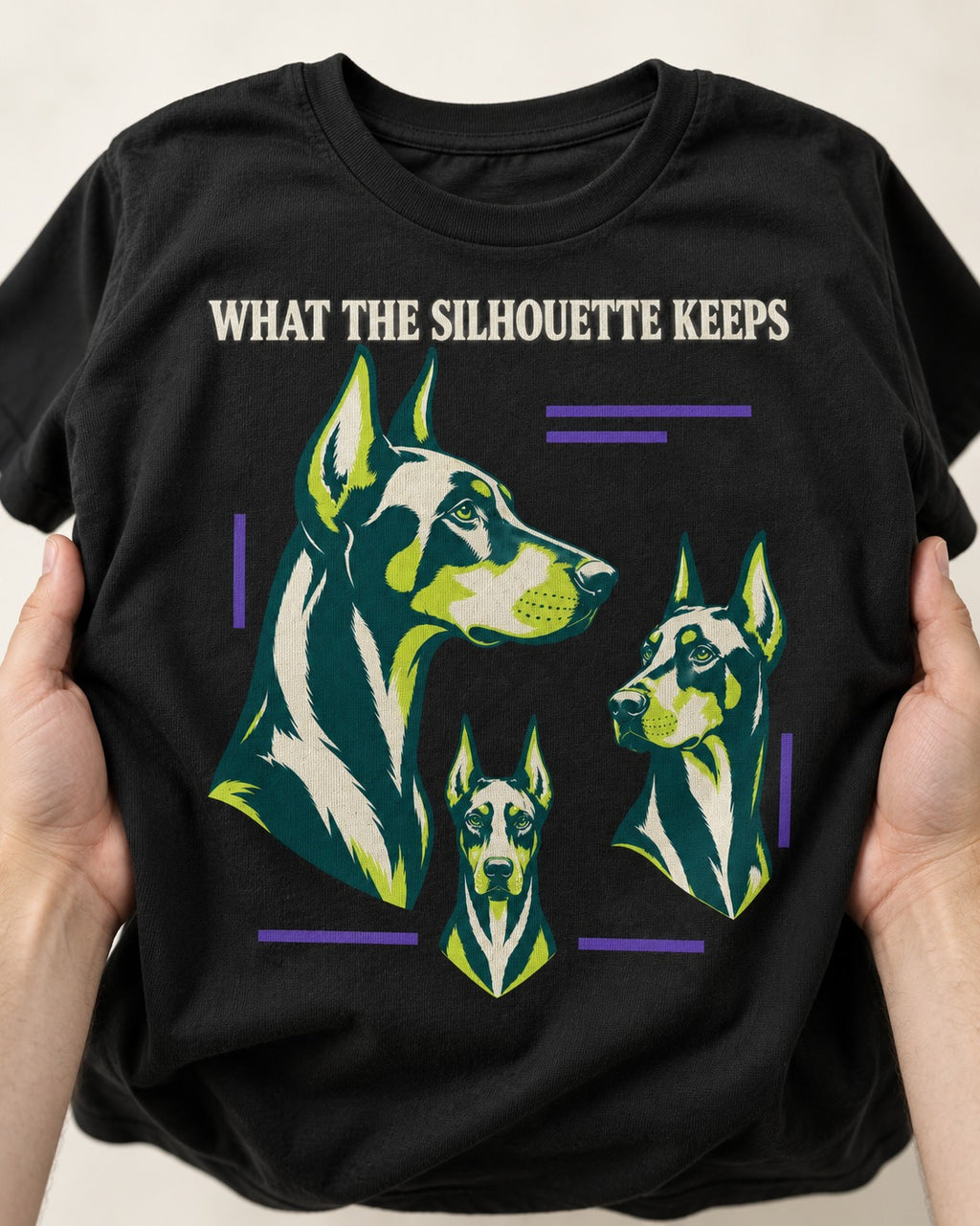 Doberman What the Silhouette Keeps Three Portrait Graphic T-Shirt in Black, close-up of the graphic