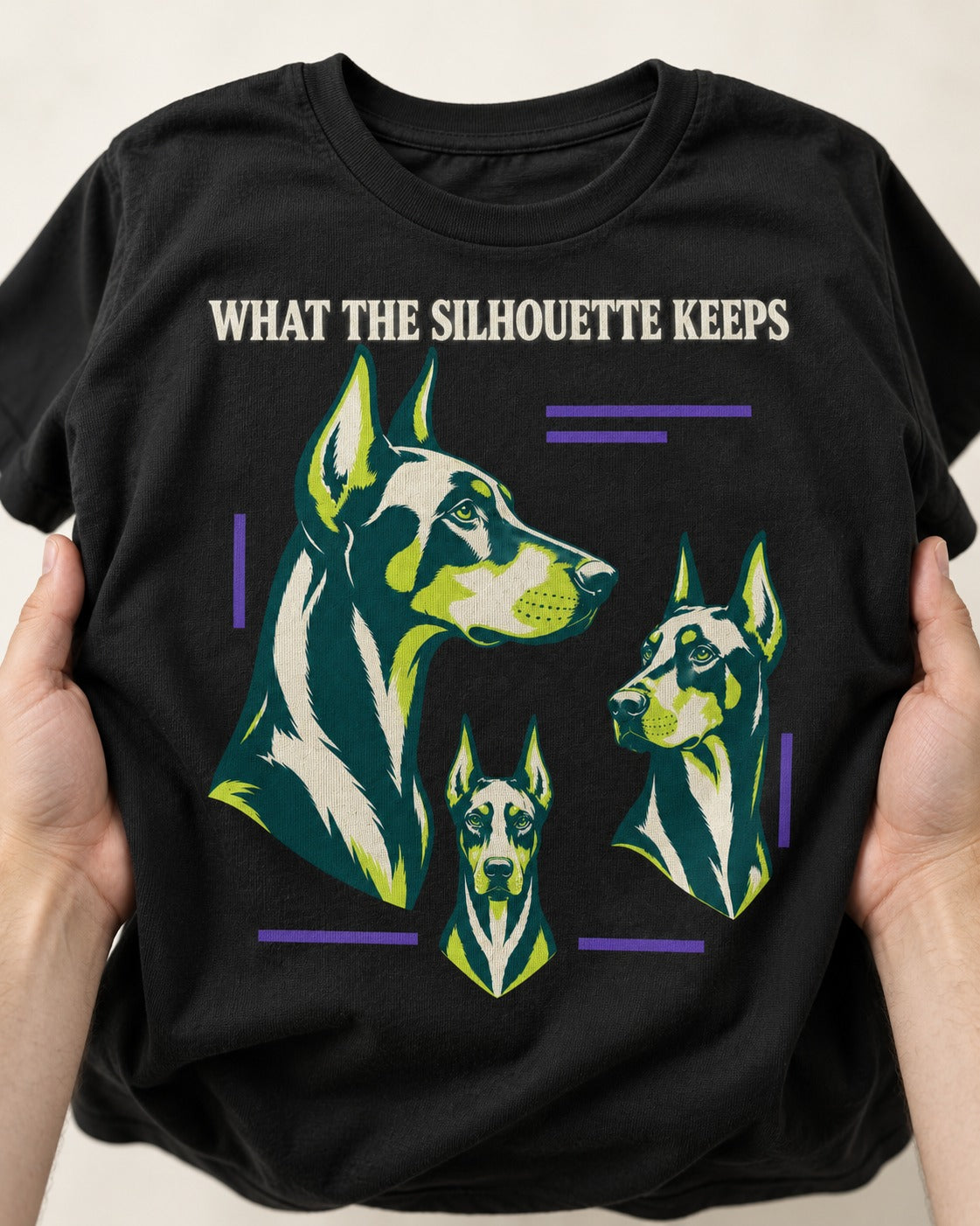 Doberman What the Silhouette Keeps Three Portrait Graphic T-Shirt in Black, close-up of the graphic