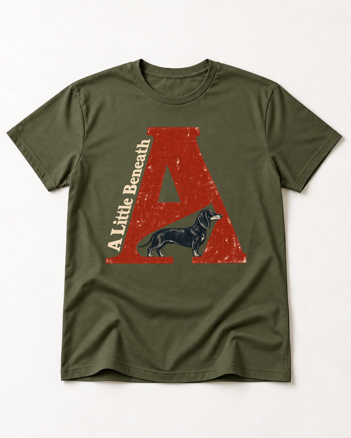 Dachshund A Little Beneath Monumental Letter Graphic T-Shirt in Heather Military Green, flat lay product photo