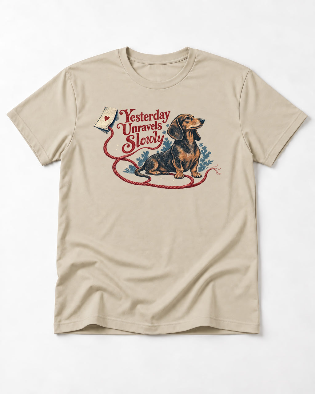 Yesterday Unravels Slowly with Dachshund T-Shirt in Sand, flat lay product photo
