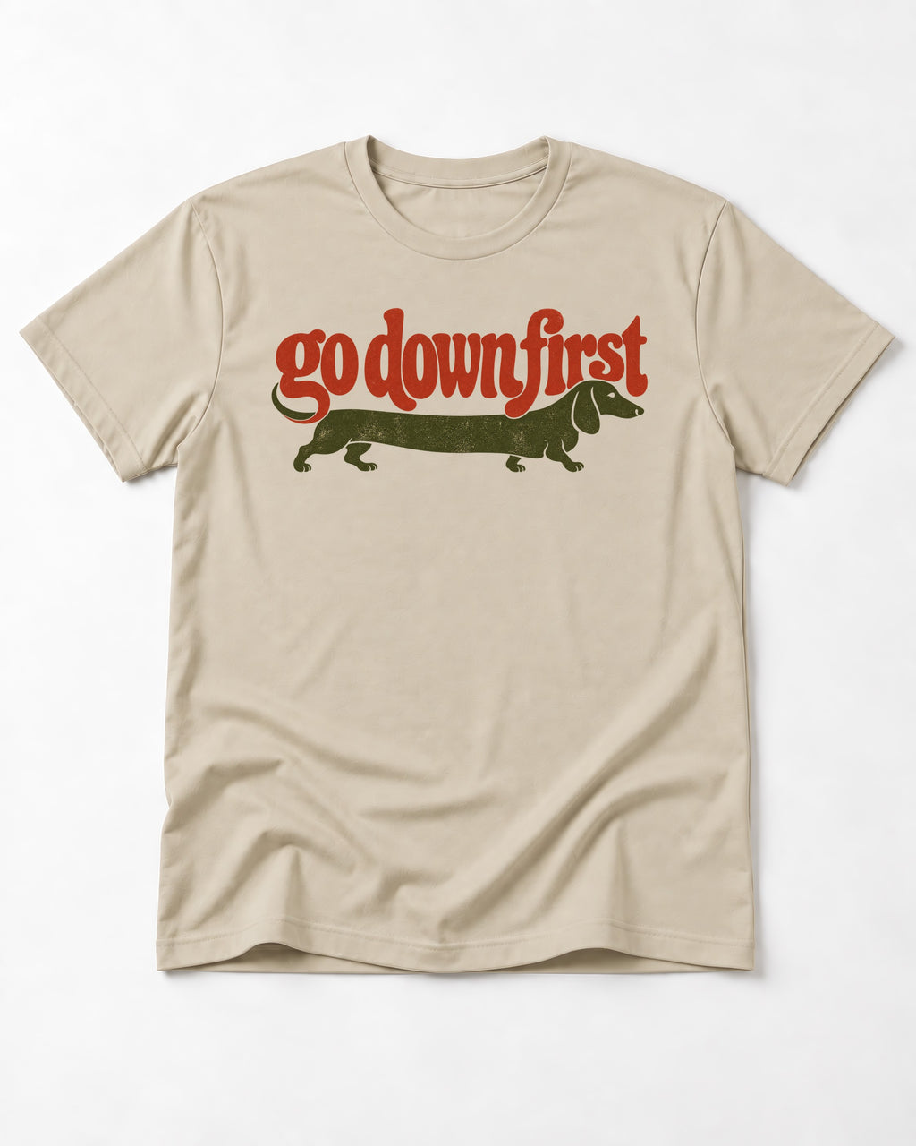 Dachshund Goes Down First T-Shirt in Sand, flat lay product photo