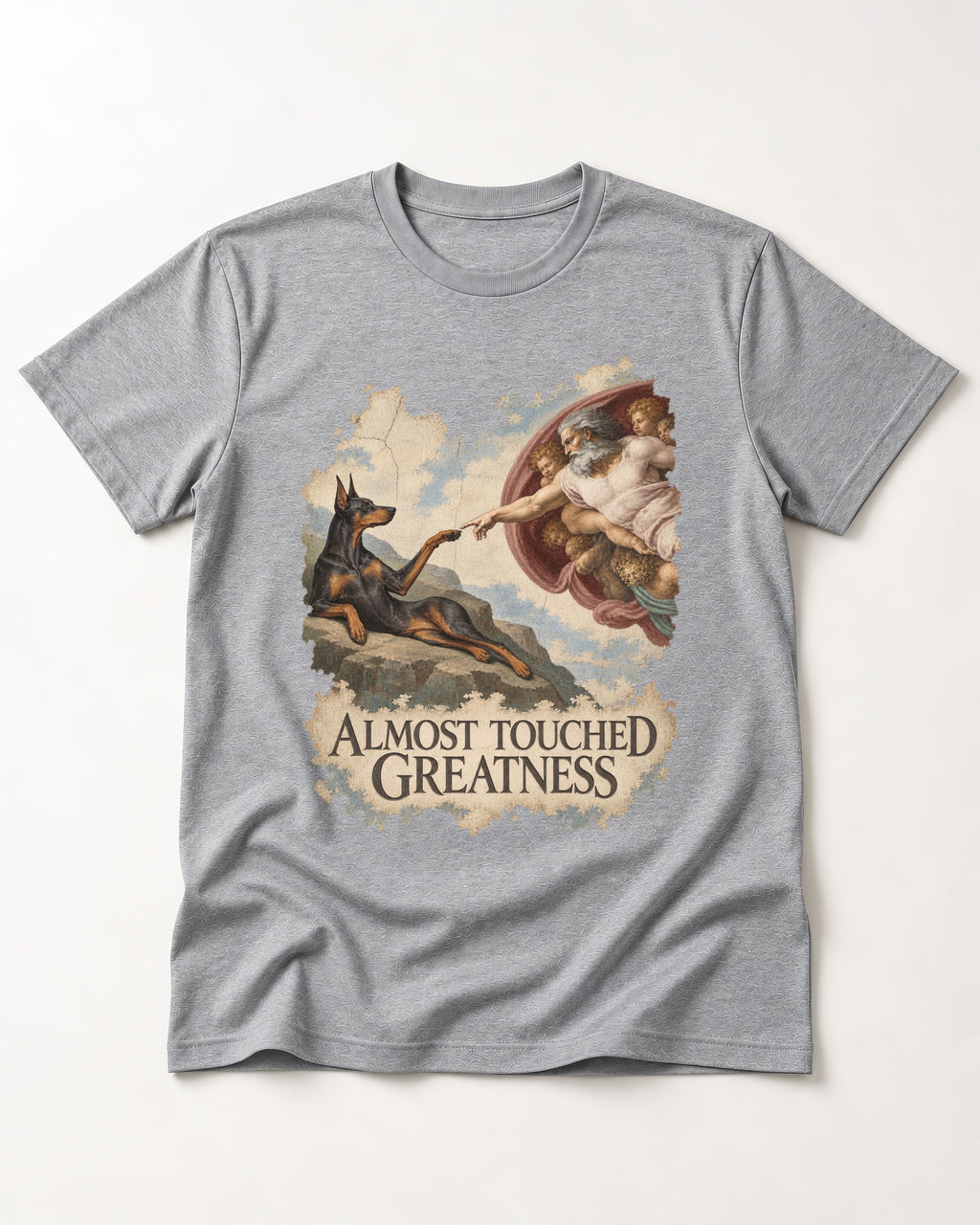 Doberman Almost Touched Greatness Creation Scene Graphic T-Shirt in Sport Grey, flat lay product photo