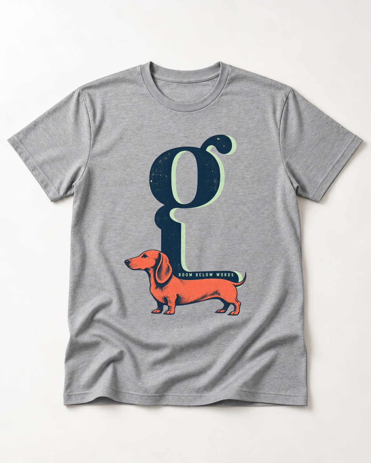 Dachshund Room Below Words Lowercase G Graphic T-Shirt in Sport Grey, flat lay product photo