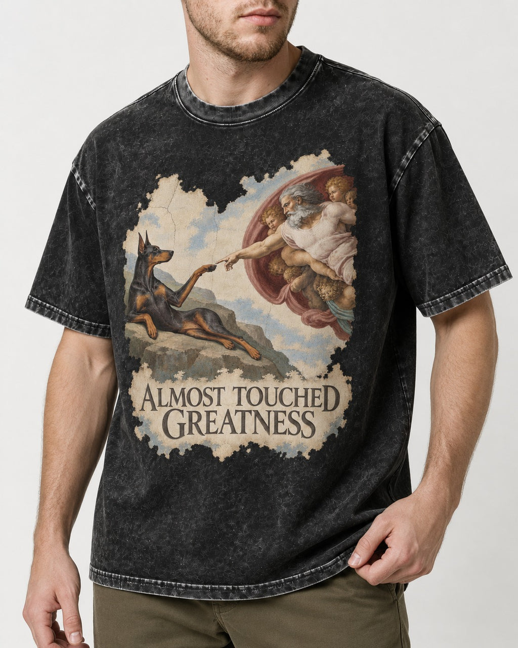 Doberman Almost Touched Greatness Creation Scene Graphic Washed Tee in Black, worn by a model, front view