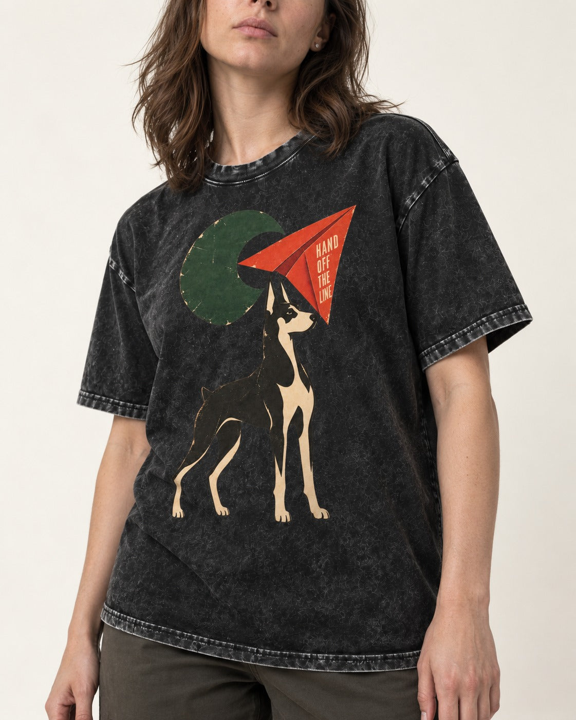 Doberman Hand Off the Line Paper Plane Graphic Washed Tee in Black, worn by a model, front view