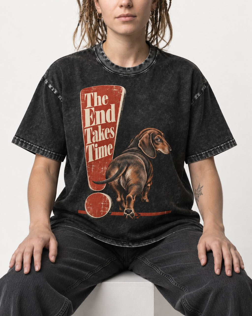 Dachshund The End Takes Time Exclamation Mark Graphic Washed Tee in Black, worn by a seated model