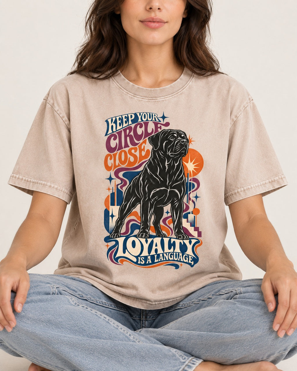 Keep Your Rottweiler Circle Close Washed Tee in Apricot, worn by a seated model