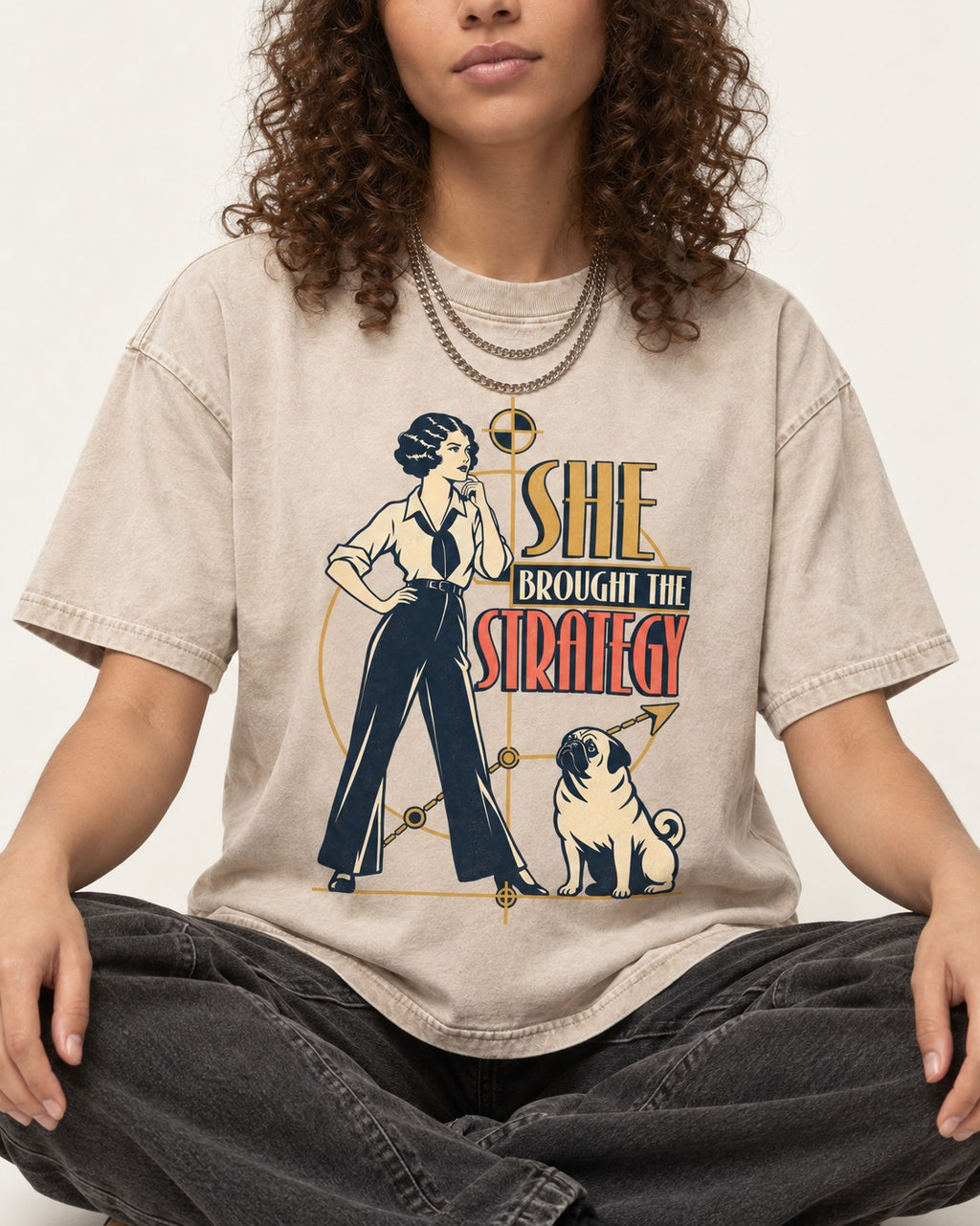 The Pug Strategy Washed Tee in Apricot, worn by a seated model