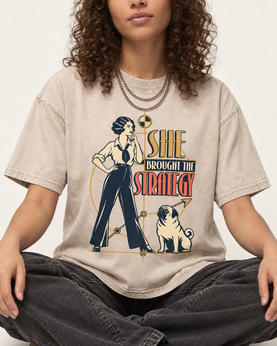 The Pug Strategy Washed Tee in Apricot, worn by a seated model