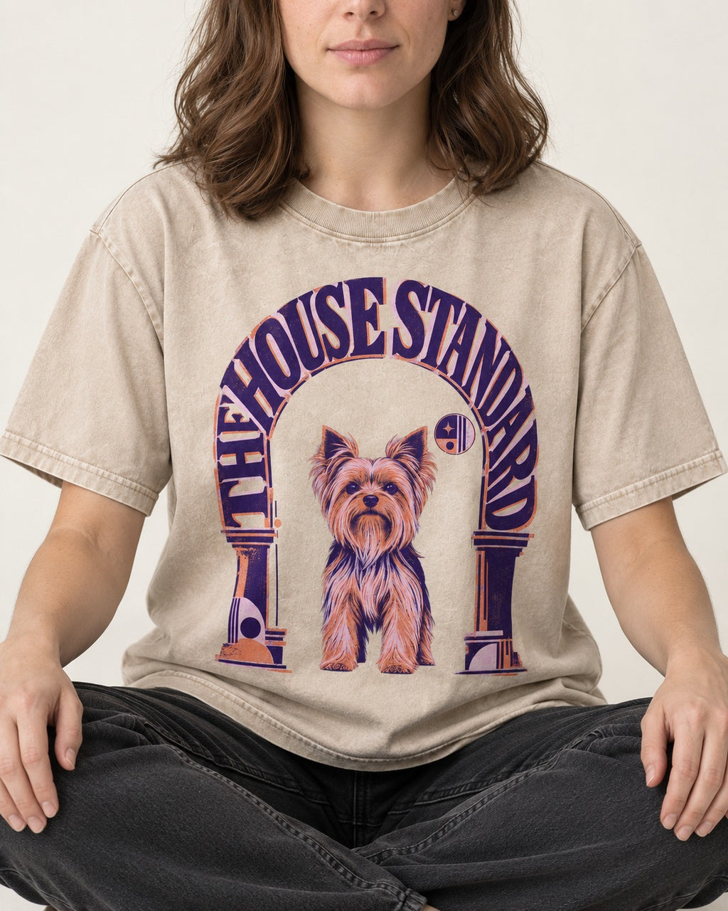 The Yorkshire Terrier House Standard Washed Tee in Apricot, worn by a seated model