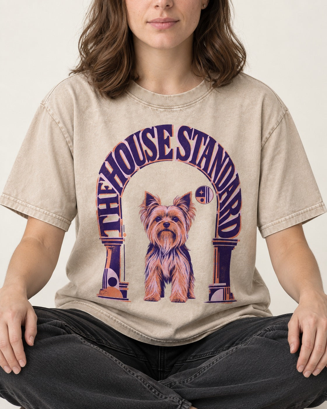 The Yorkshire Terrier House Standard Washed Tee in Apricot, worn by a seated model