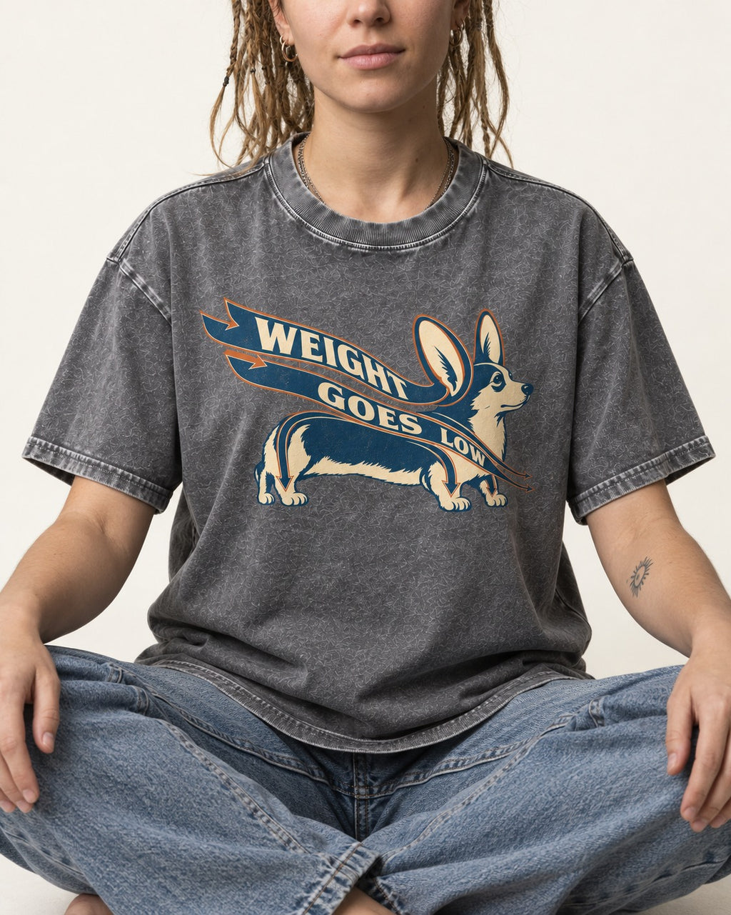 Corgi Weight Goes Low Ribbon Arrow Graphic Washed Tee in Gray, worn by a seated model