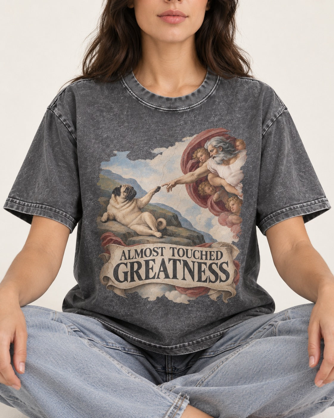Pug Almost Touched Greatness Creation Parody Graphic Washed Tee in Gray, worn by a seated model