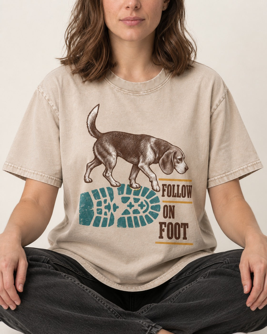 Follow the Beagle on Foot Washed Tee in Apricot, worn by a seated model