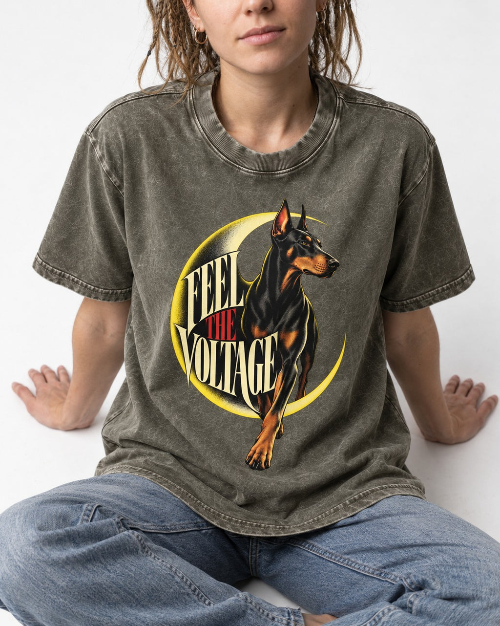 Doberman Feel the Voltage Crescent Portrait Graphic Washed Tee in Army Green, worn by a seated model