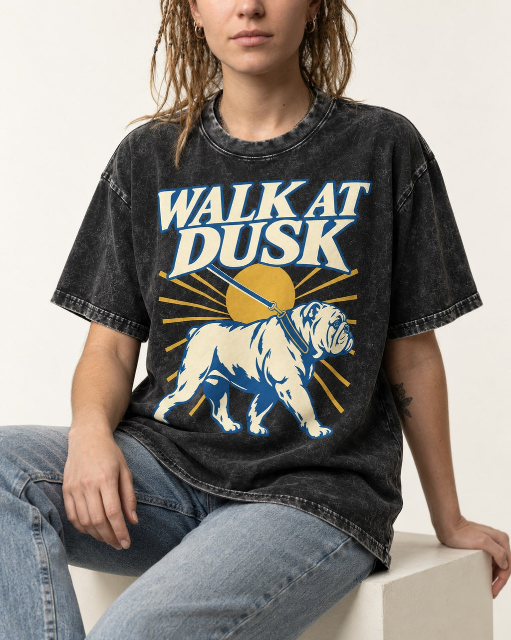 English Bulldog Walk at Dusk Sunset Graphic Washed Tee in Black, worn by a seated model