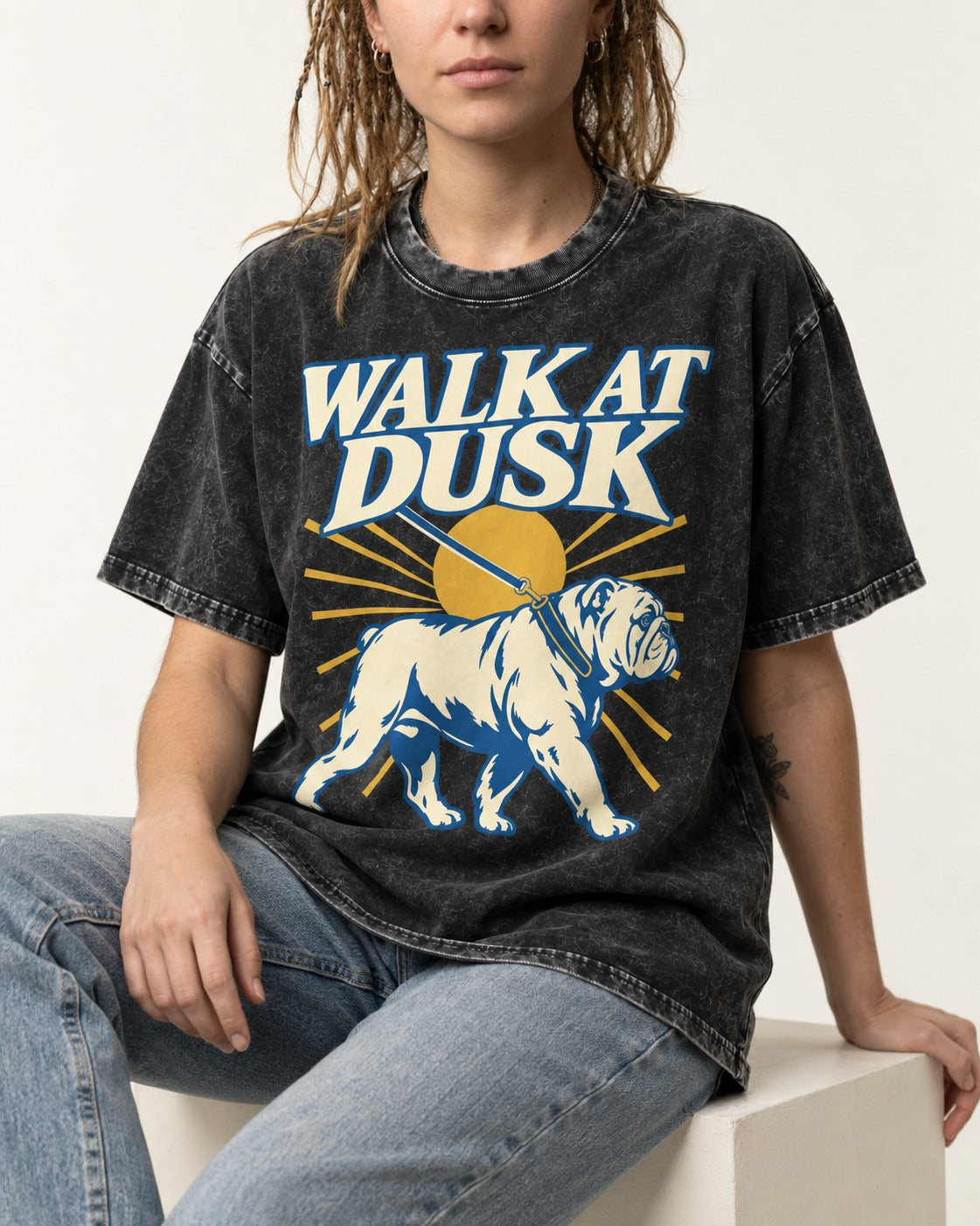 English Bulldog Walk at Dusk Sunset Graphic Washed Tee in Black, worn by a seated model
