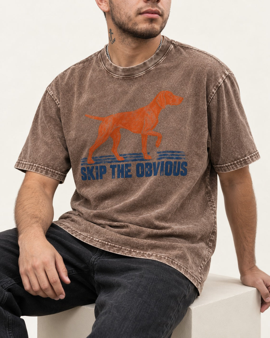 Skip the Obvious German Shorthaired Pointer Washed Tee in Coffee, worn by a seated model