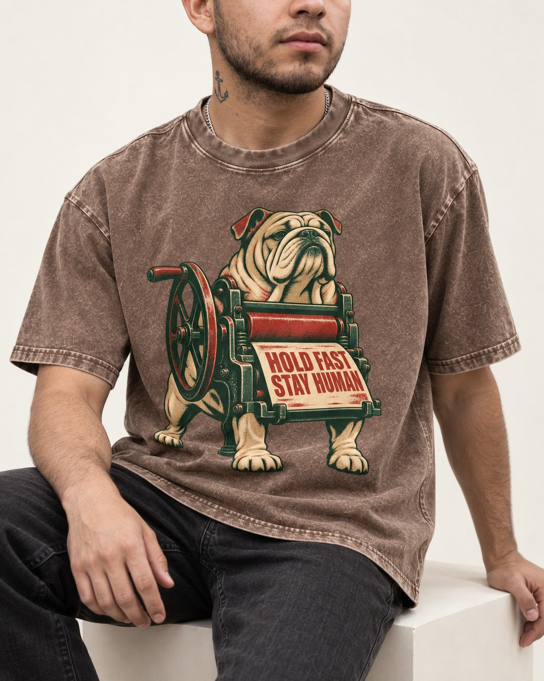 Hold Fast Stay Human English Bulldog Washed Tee in Coffee, worn by a seated model