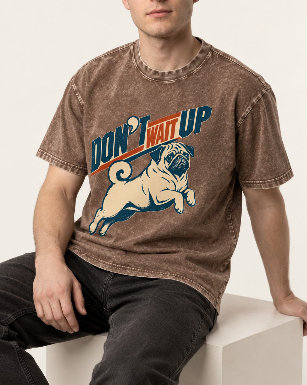 Don't Wait Up for Pug Washed Tee in Coffee, worn by a seated model
