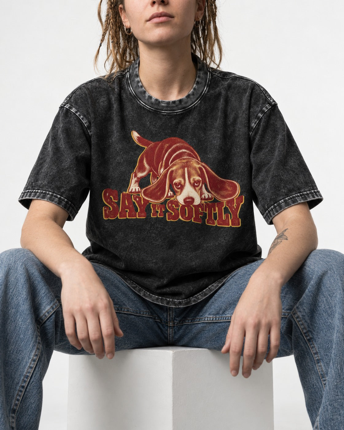 Beagle Say It Softly Washed Tee in Black, worn by a seated model