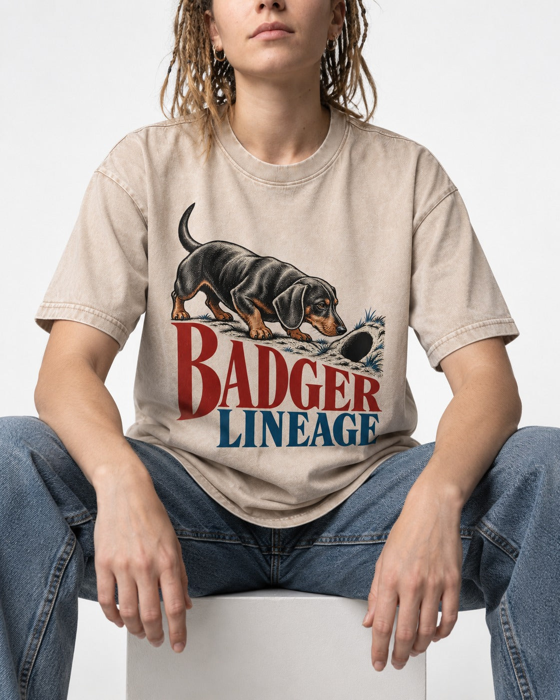 Dachshund Badger Lineage Burrow Graphic Washed Tee in Apricot, worn by a seated model