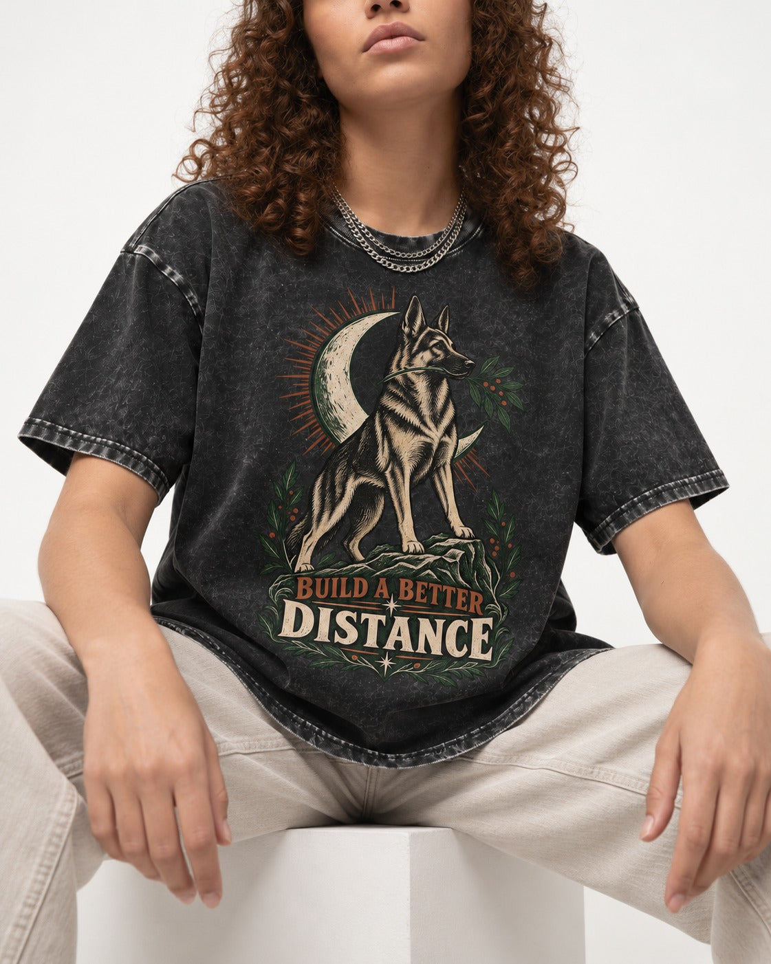 Build A Better Distance Moon Woodcut German Shepherd Dog Graphic Washed Tee in Black, worn by a seated model