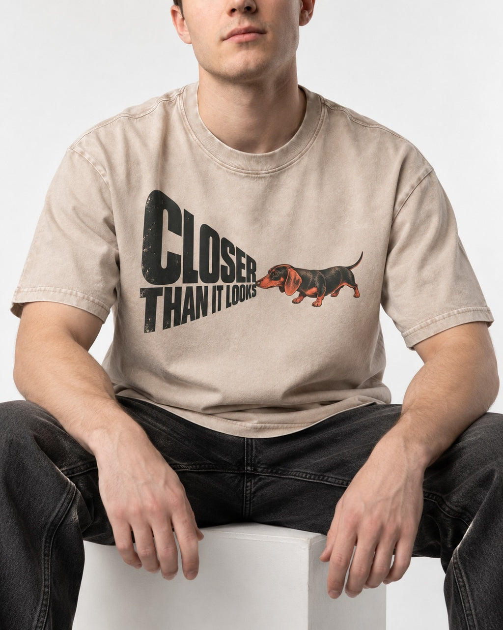 Dachshund Closer Than It Looks Washed Tee in Apricot, worn by a seated model