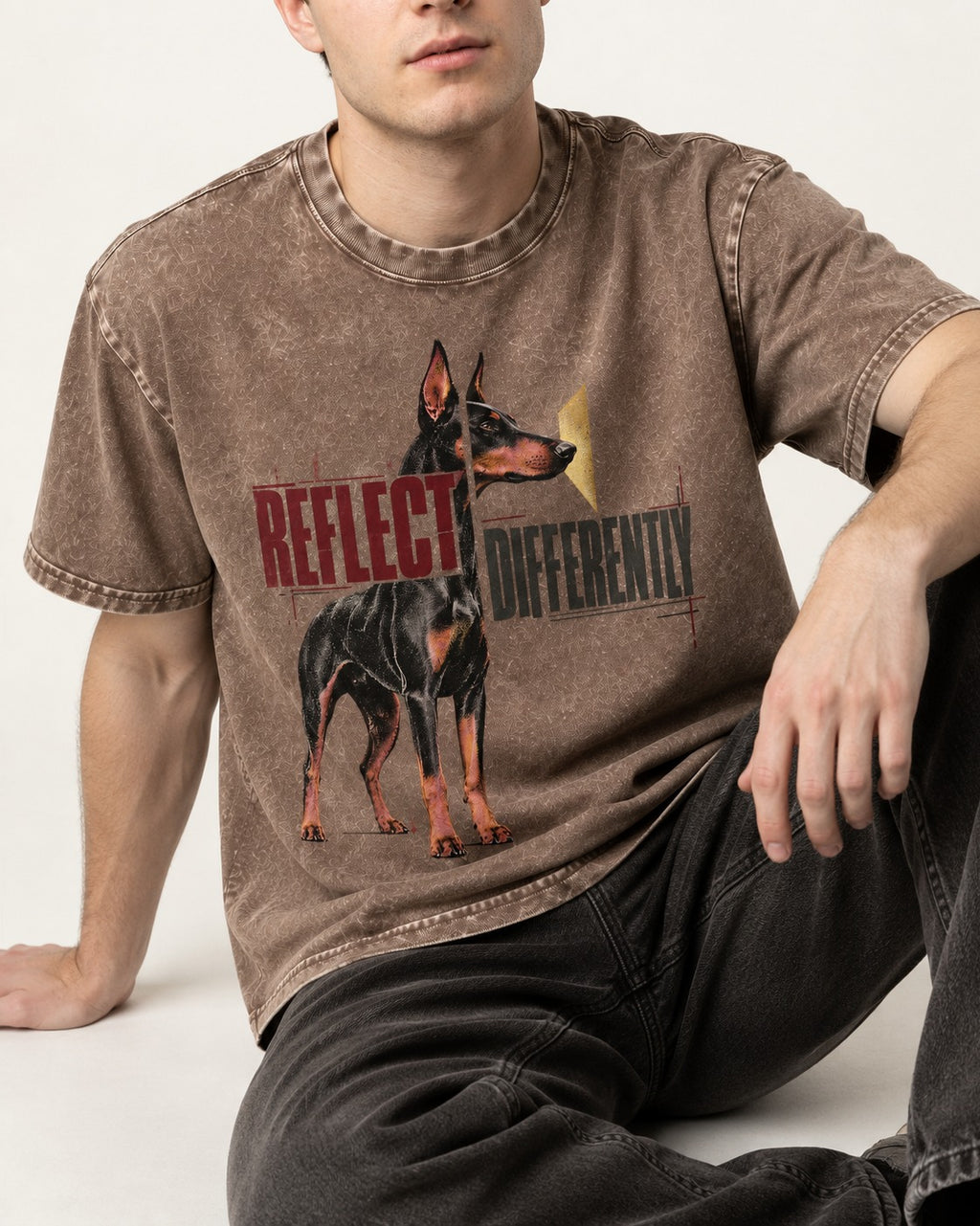Doberman Reflects Differently Washed Tee in Coffee, worn by a seated model