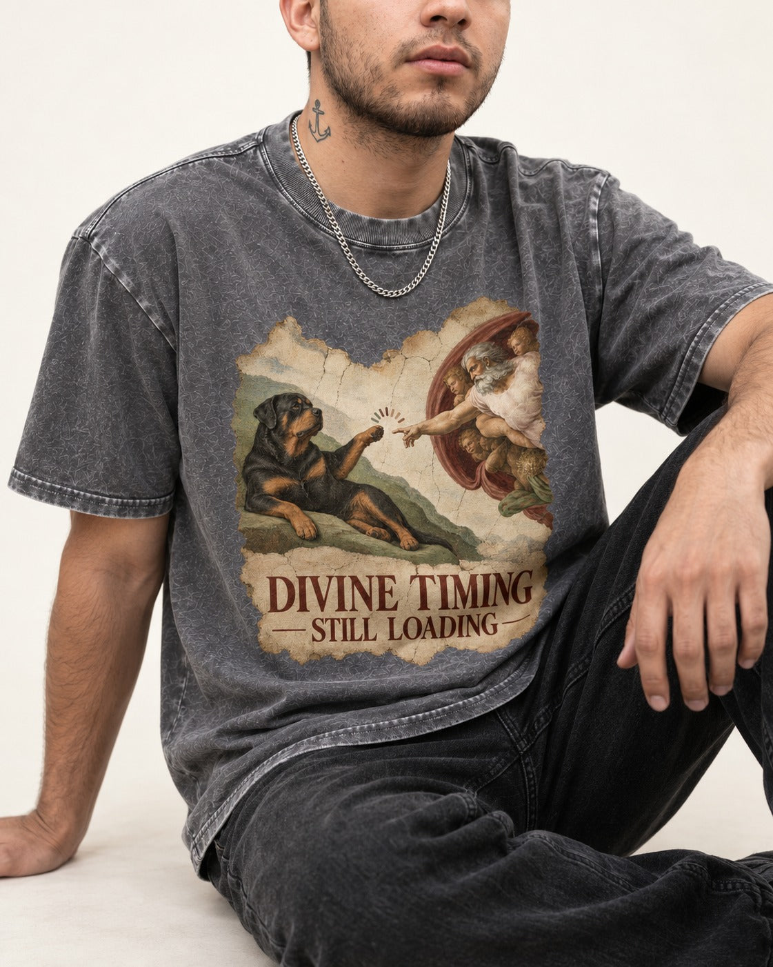 Rottweiler Divine Timing Still Loading Creation Parody Graphic Washed Tee in Gray, worn by a seated model